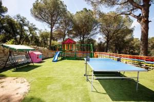 托尔德拉Maravillosa casa con piscina grande y bosque的乒乓球桌和院子内的游乐场