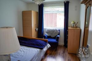 卡纳芬The Cabin, Glan Gwna的卧室配有床、椅子和窗户。