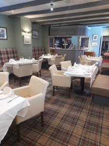 阿尔恩茅斯 纵帆船酒店的用餐室配有白色的桌子和白色的椅子