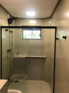 卡皮托利乌ESCARPAS FLATS的浴室里设有玻璃门淋浴