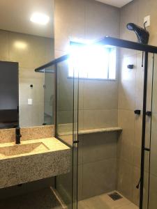 卡皮托利乌ESCARPAS FLATS的带淋浴、盥洗盆和镜子的浴室