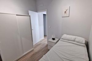 马德里Loft en Madrid junto al metro.的白色卧室配有床和镜子
