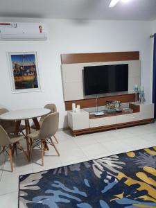 塞古罗港Casa Duplex Aconchegante de Frente para o Mar的客厅配有电视和桌椅