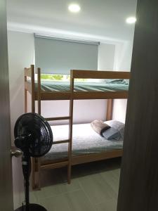 卡利Hermoso para estrenar的客房设有两张双层床和风扇。