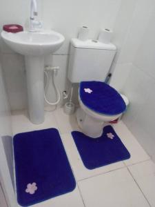 里约热内卢Cantinho da Alegria的浴室设有卫生间、水槽和蓝色垫子。