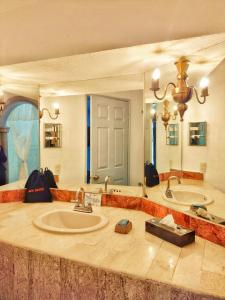 萨卡特卡斯Hotel & Spa Hacienda Baruk的大型浴室设有两个盥洗盆和大镜子