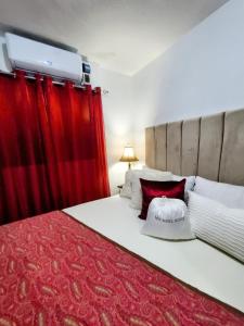 MandingaComo en Casa的一间卧室配有一张带红色窗帘的大床