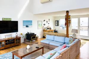 Westhampton BeachToes in the Sand的客厅配有蓝色的沙发和电视