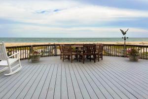 Westhampton BeachToes in the Sand的海滩上带桌椅的木制甲板