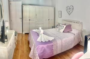 格拉纳达Luna Centro 5 habitaciones的一间卧室配有一张大床,铺有紫色和白色的床单。