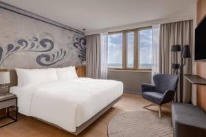 美因河畔法兰克福法兰克福万豪酒店的卧室配有白色的床和椅子