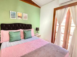 布希奥斯1 Quarto Pra 2 Búzios的一间卧室配有一张粉红色和绿色的床