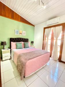 布希奥斯1 Quarto Pra 2 Búzios的一间卧室设有粉红色的床和绿色的墙壁