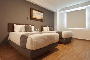 莱昂Hoteles Unico Express的一间卧室设有两张床和窗户。