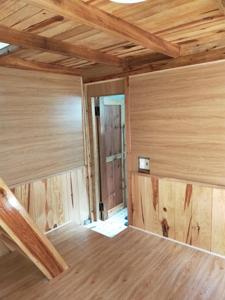 大叻Đà Lạt Củi Homestay的木墙和木制天花板的客房