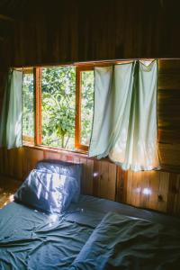 大叻Đà Lạt Củi Homestay的窗户客房内的一张床位