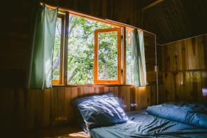 大叻Đà Lạt Củi Homestay的一间卧室设有一张床和一个窗口