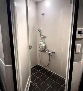 石垣岛とぅも～る的浴室铺有黑色瓷砖地板,设有淋浴。