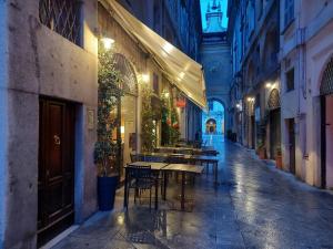 布雷西亚FiorDiLuna, nel cuore di Brescia的大楼里一座带桌椅的空洞小巷