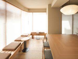 东京东京浅草筑波快速船舶酒店(Vessel Inn Asakusa Tsukuba Express)的一间设有长椅和桌子的会议室以及大窗户