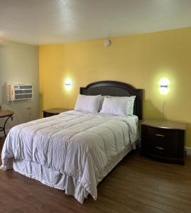 MoapaMoapa Motel的一间卧室配有一张大床、两张桌子和两盏灯。