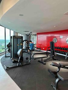 巴生Cozy 2 BR Apartment w/ Pool Gym Wi-Fi & Work Space的健身房设有有氧器材和红色墙壁