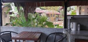 珍南海滩Bunga Hostel的窗户前的一张木桌和椅子