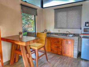 马萨米特拉Chalet 08的厨房配有木桌和水槽。
