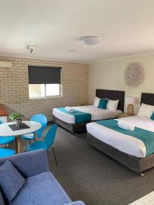 North WollongongBeach Park Motel的酒店客房带两张床和一张桌子以及椅子。