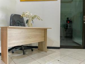 泗水Monalisa Homestay Mitra RedDoorz的一张木桌,上面有花瓶