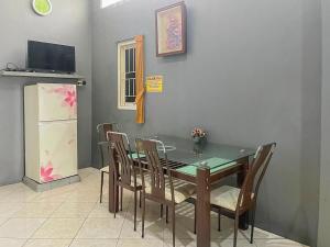 泗水Monalisa Homestay Mitra RedDoorz的一间带桌椅和冰箱的用餐室