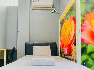 泗水Monalisa Homestay Mitra RedDoorz的配有一张带枕头和绘画的床的房间