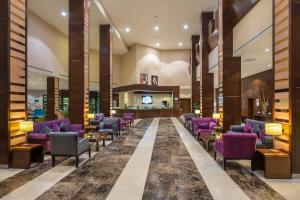 利雅德利雅得圣堡假日酒店的大堂设有紫色椅子和等候室