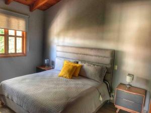马萨米特拉Cabaña Familiar 10的一间卧室配有一张带两个黄色枕头的床