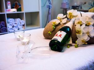 巴特基辛根维托埃里卡酒店的床上的鲜花盛开的一瓶葡萄酒和玻璃杯