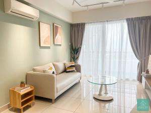怡保JOMSTAY Majestic Ipoh Suites的带沙发和玻璃桌的客厅