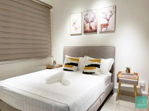 怡保JOMSTAY Majestic Ipoh Suites的一间卧室配有带白色床单和枕头的床。
