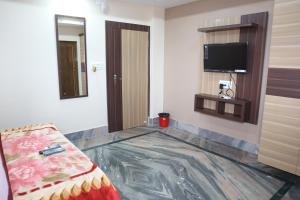 HaldiaSTAYMAKER Hotel Suraj - Only Indian Citizens Allowed的客房设有一张床和一台平面电视。