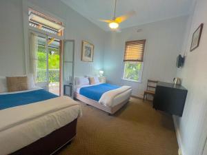 Ulmarra厄马拉酒店的一间卧室设有两张床和窗户。