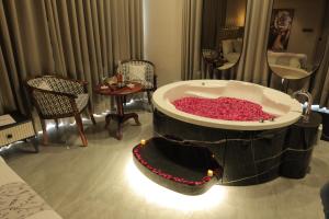 艾哈迈达巴德Apricot Motera的一间酒店客房内装满红色鲜花的大浴缸