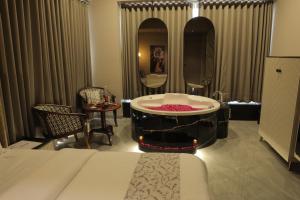 艾哈迈达巴德Apricot Motera的一间卧室配有带镜子的浴缸和一张床