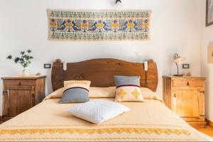 UrzuleiB&B Su Biancu - Sardinian Experience的一间卧室配有一张带枕头的木床