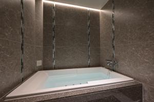 名古屋Hotel Pasadena レジャーホテル的带浴缸的浴室和瓷砖墙