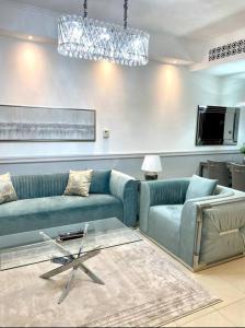 迪拜Lux Burj views -Boulevard -Prime Location Downtown DUBAI的客厅配有2张蓝色的沙发和1张桌子