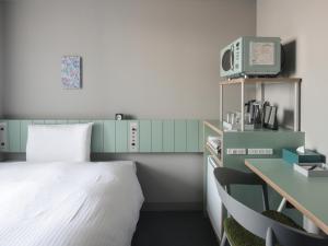东京Vessel Inn Takadanobaba Ekimae的一间卧室配有一张床和一张带电脑的书桌