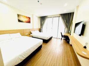 下龙湾Orion Hotel Halong的酒店客房配有两张床和一张书桌