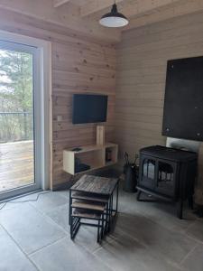 巴斯托涅Cosy chalet in nature的客厅设有壁炉和平面电视。
