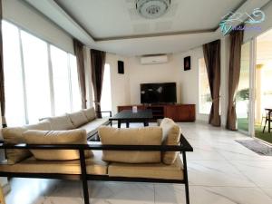 芭堤雅市中心TY假日度假村的客厅配有沙发和桌子