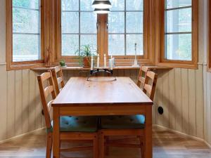 英斯约Holiday home YNGSJÖ III的餐桌、两把椅子和两扇窗户