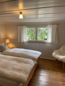 罗曼斯霍恩Fischerhäuser Romanshorn的一间卧室设有两张床和窗户。